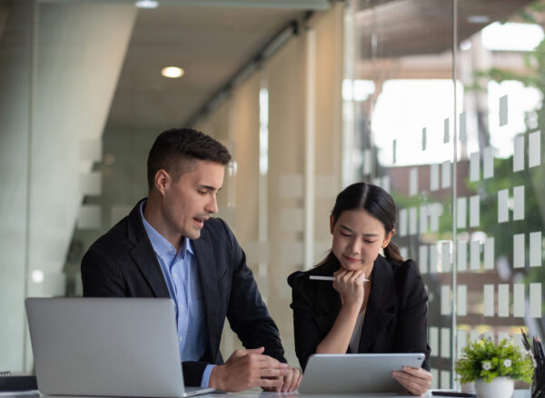 Diverse business people working together with laptop and digital tablet in office meeting room. Diverse business people working together with laptop and digital tablet in office meeting room