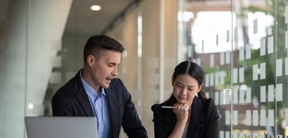 Diverse business people working together with laptop and digital tablet in office meeting room