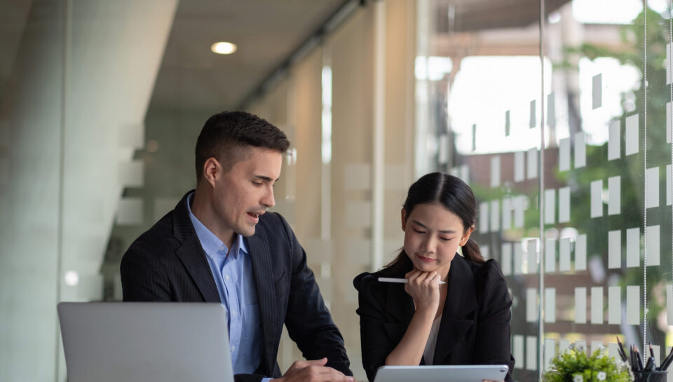 Diverse business people working together with laptop and digital tablet in office meeting room