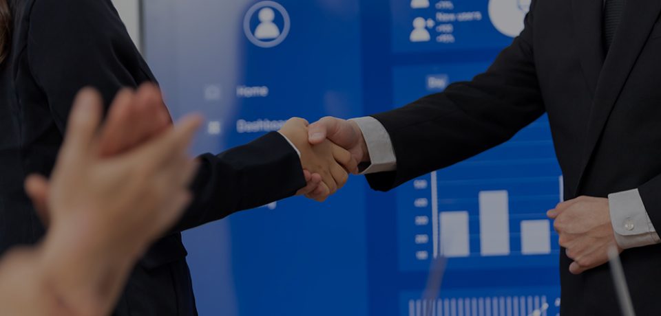Closeup office worker shake hand business team leader manager for strong teamwork in office to promote harmony concept after successful agreement or meeting with dashboard report on screen background.