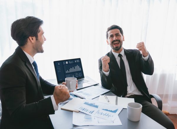 two-men-sitting-table-with-laptops-papers-table two-men-sitting-table-with-laptops-papers-table