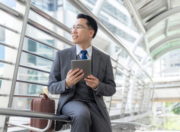 Portrait asian business man business district ,senior visionary executives leader with business vision , tabled phone computer in hand - lifestyle business people concept