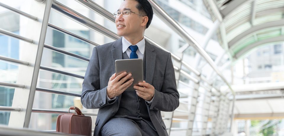 Portrait asian business man business district ,senior visionary executives leader with business vision , tabled phone computer in hand - lifestyle business people concept